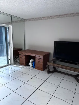 a living room with a black white checkered floor and a large window