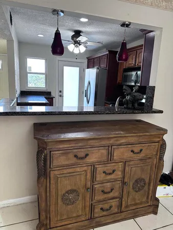 a bedroom with a bed a dresser and windows