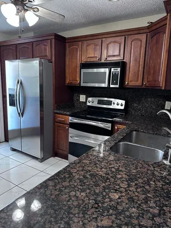 a kitchen with stainless steel appliances granite countertop a refrigerator a stove top oven a sink and dishwasher