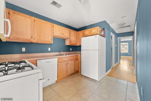 a kitchen with a refrigerator a stove top oven a sink and cabinets