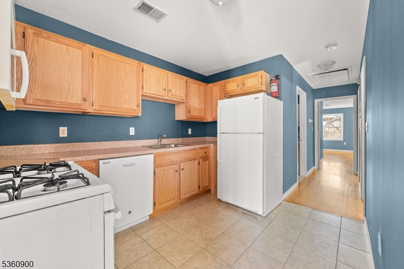427 Fulton Street, Unit 2 Elizabeth Port, NJ 07206 - Photo 8 of 17 a kitchen with a refrigerator a stove top oven a sink and cabinets
