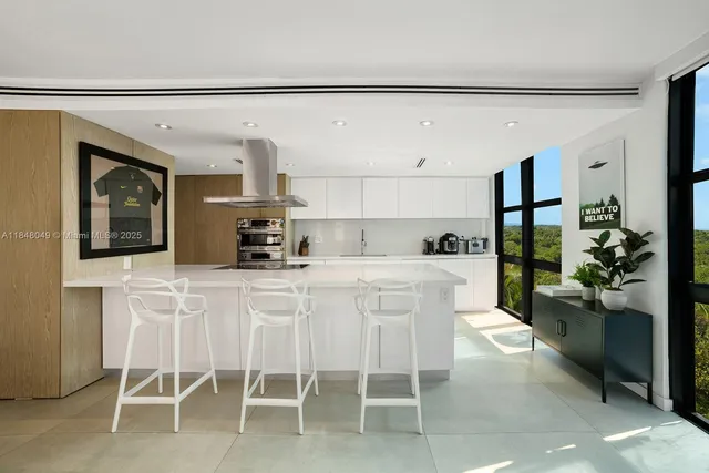 a kitchen with a sink and chairs