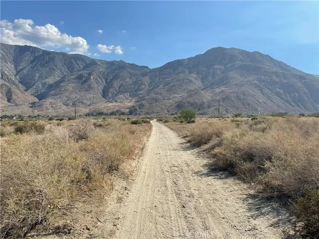 a view of a dry yard with mountains in the background