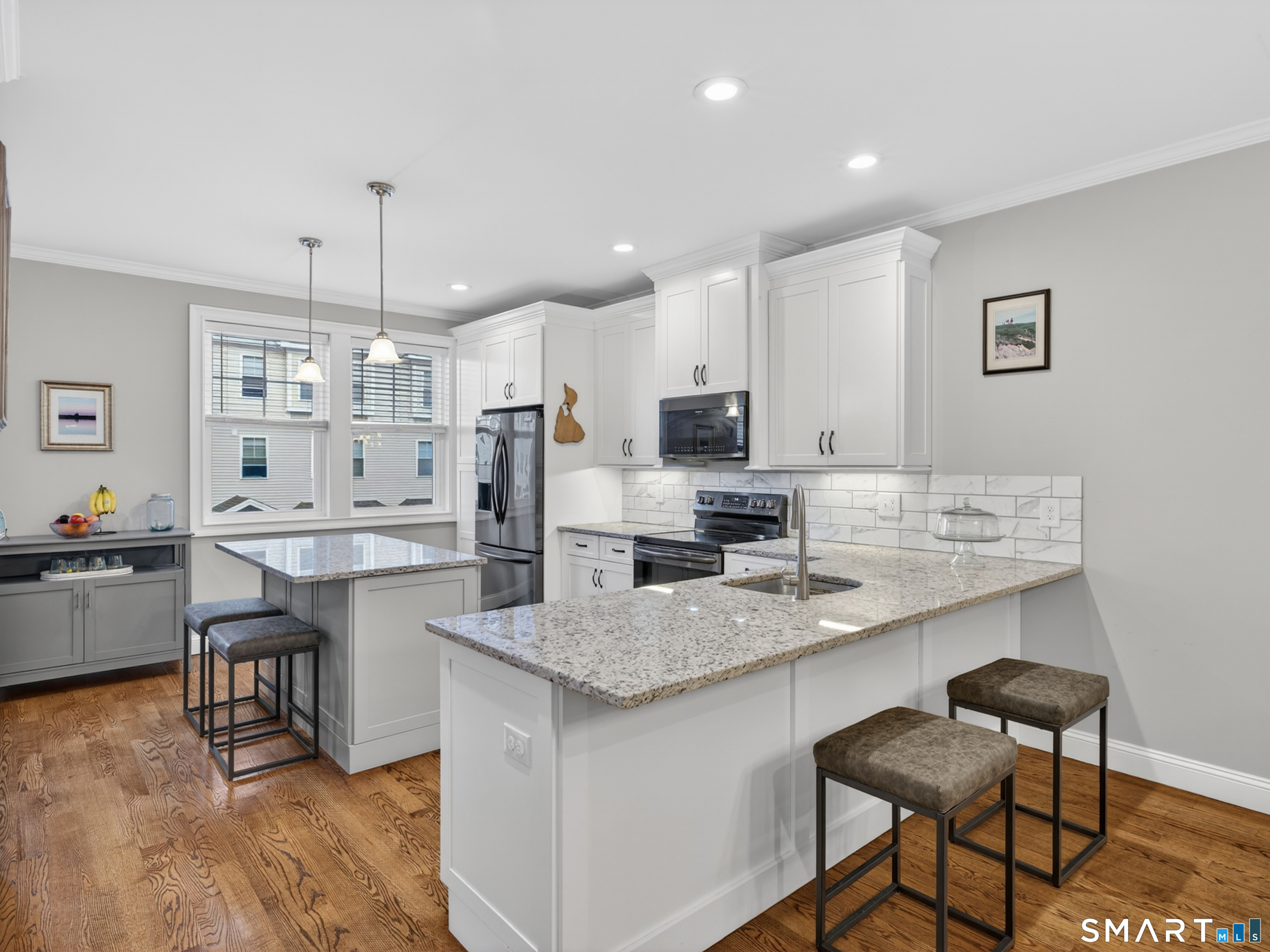 34 Village Crossing, Unit 34 Niantic, CT 06357 - Photo 14 of 38 a kitchen with kitchen island a dining table chairs sink and cabinets