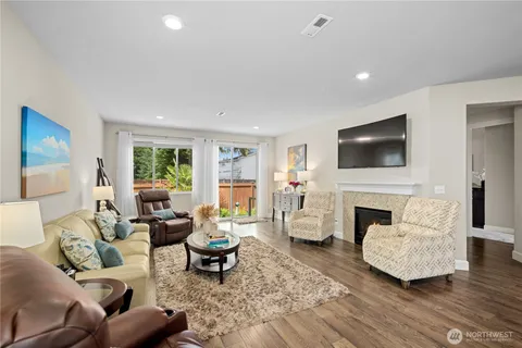 a living room with furniture a fireplace and a flat screen tv