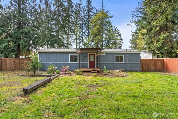 front view of a house with a yard and trees