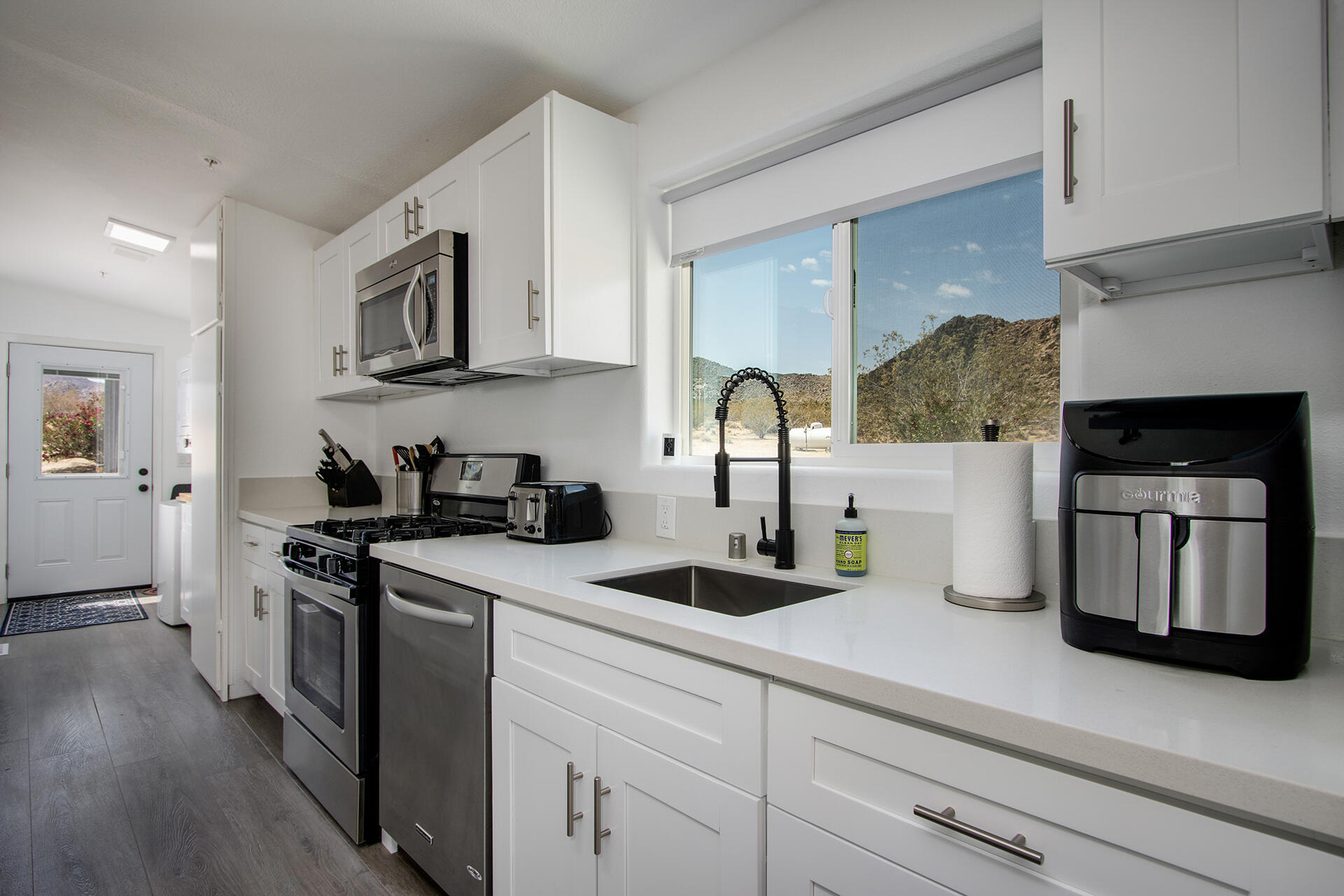 7122 Sunkist Road Joshua Tree, CA 92252 - Photo 37 of 61 a kitchen with stainless steel appliances granite countertop a sink and a stove