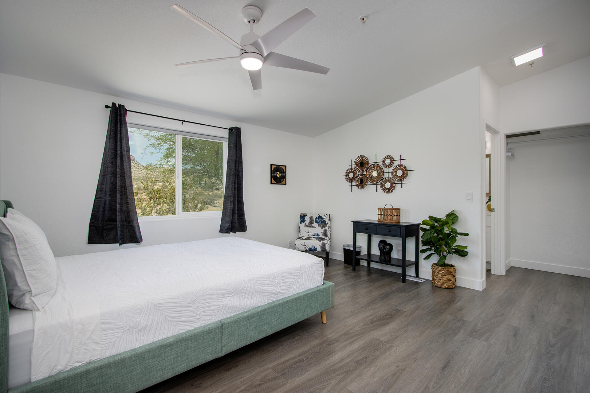 7122 Sunkist Road Joshua Tree, CA 92252 - Photo 52 of 61 a bedroom with a large bed chandelier and a window