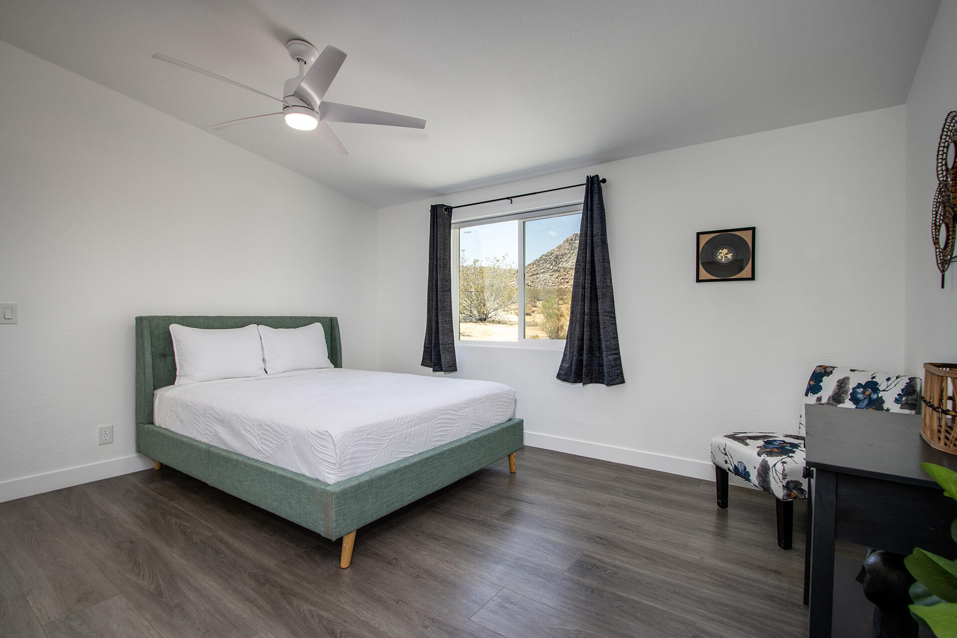 7122 Sunkist Road Joshua Tree, CA 92252 - Photo 53 of 61 a bedroom with a bed and a table in it with wooden floor