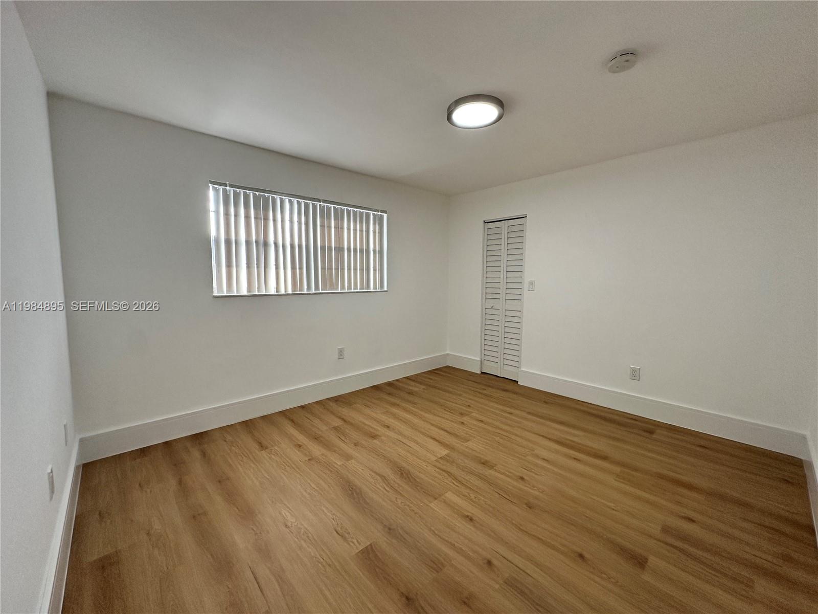 10425 Southwest 112th Avenue, Unit 324 Miami, FL 33176 - Photo 11 of 22 an empty room with wooden floor and windows