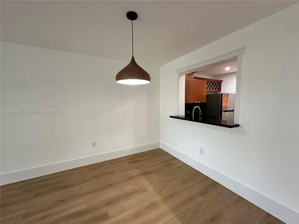 a view of a room with a chandelier fan and wooden floor