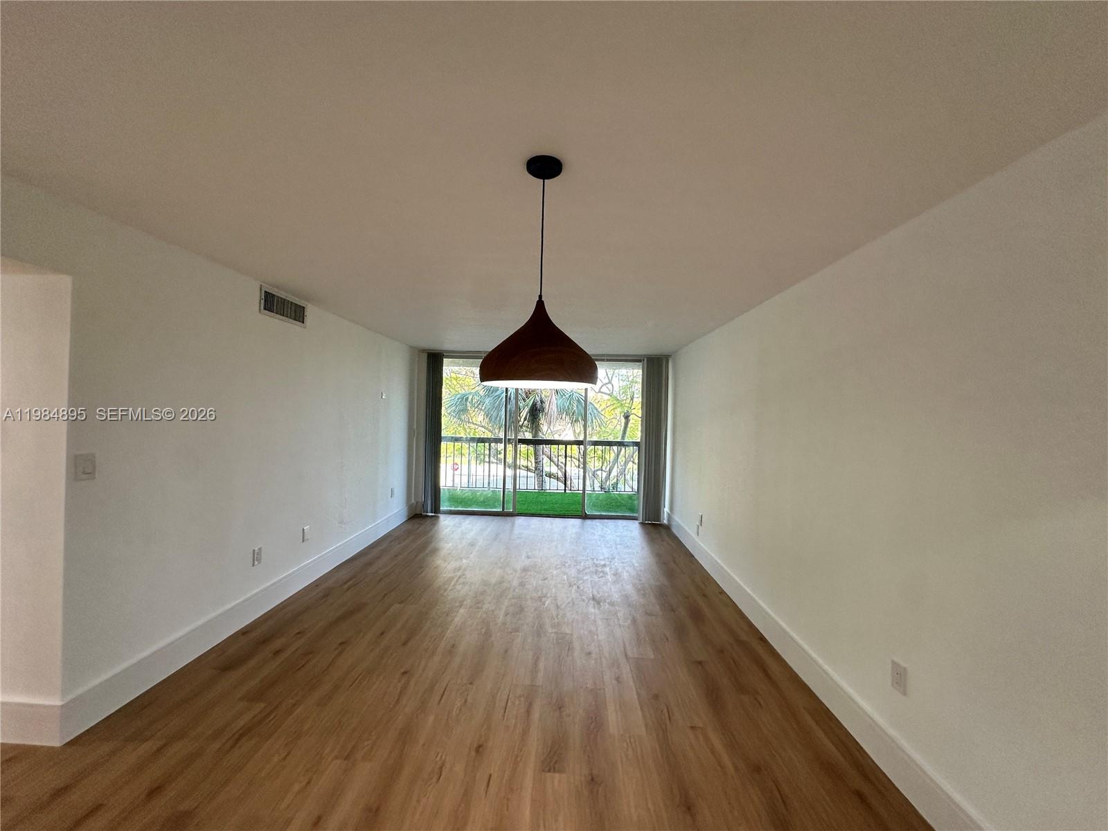 10425 Southwest 112th Avenue, Unit 324 Miami, FL 33176 - Photo 15 of 22 a view of an empty room with wooden floor and a window