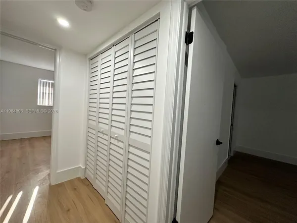 a view of hallway with stairs and wooden floor