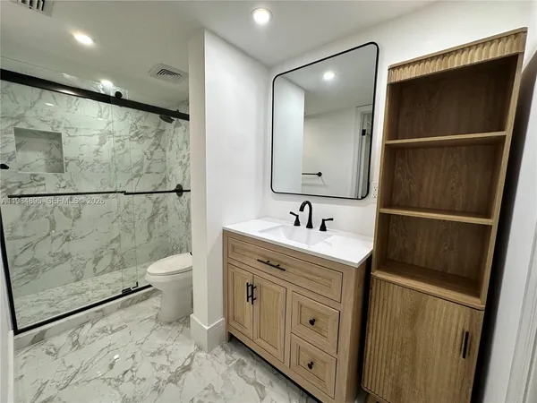 a bathroom with a sink a toilet and mirror