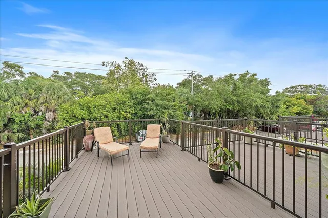 a view of a balcony with wooden floor and iron fence