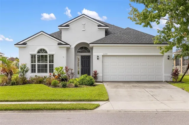 a living room with furniture kitchen view and a chandelier