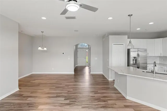 a kitchen with a sink chandelier and a wooden floor