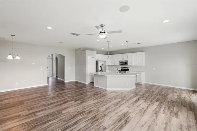 a view of a room with wooden floor and a ceiling fan