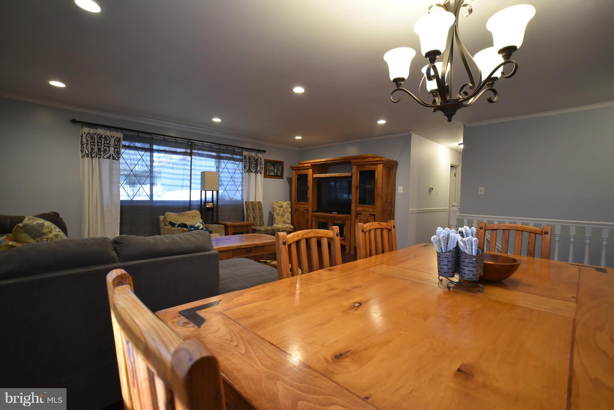 8645 Victoria Road Springfield, VA 22151 - Photo 6 of 19 a dining room with furniture a chandelier and wooden floor