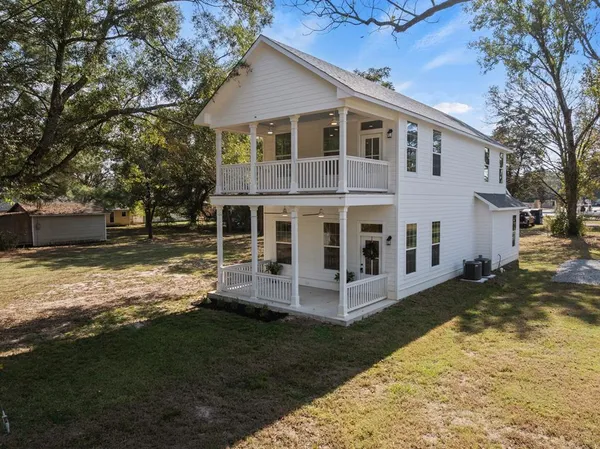 a view of a house with backyard and sitting area