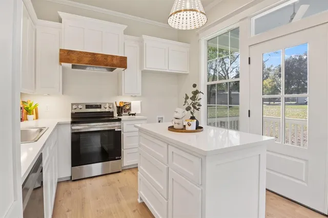 a kitchen with stainless steel appliances a stove a sink and a refrigerator