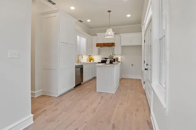 a view of a kitchen with a sink refrigerator and wooden floor