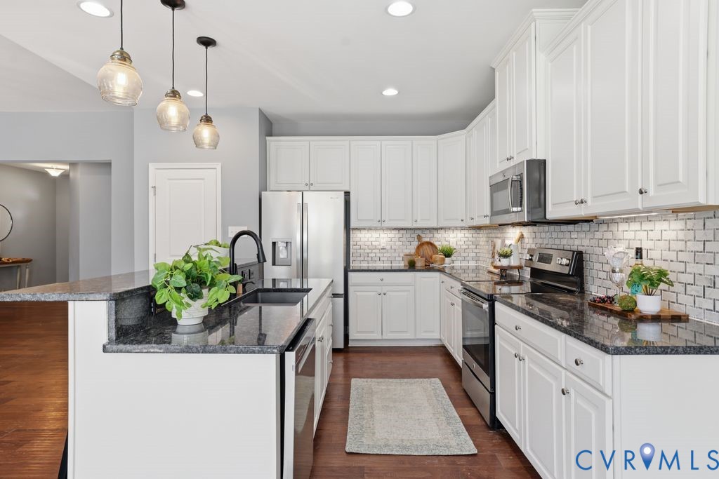 8712 Bailey Hill Road Midlothian, VA 23112 - Photo 13 of 46 a kitchen with stainless steel appliances granite countertop a refrigerator a sink dishwasher and white cabinets with wooden floor