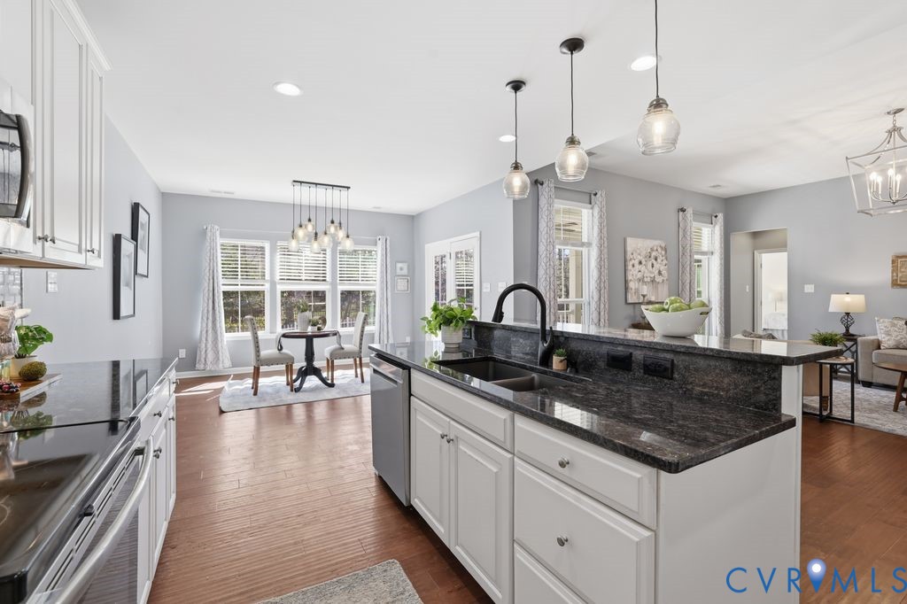8712 Bailey Hill Road Midlothian, VA 23112 - Photo 15 of 46 a large kitchen with granite countertop a white stove top oven a dining table and chairs