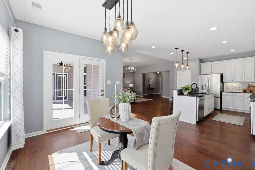 8712 Bailey Hill Road Midlothian, VA 23112 - Photo 20 of 46 a view of a dining room with furniture a chandelier and wooden floor