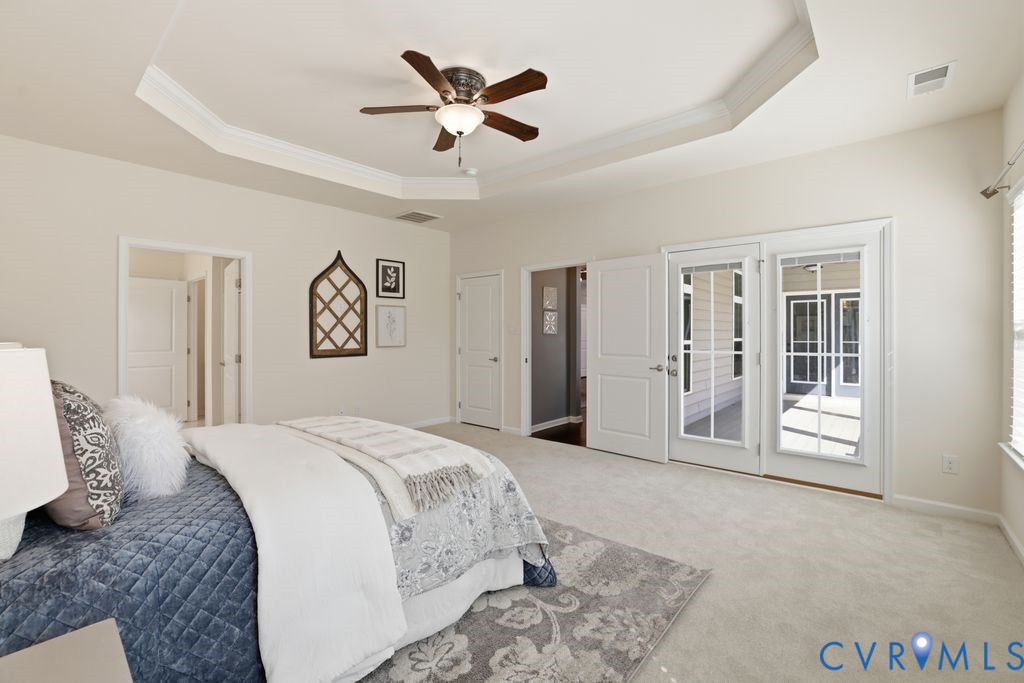 8712 Bailey Hill Road Midlothian, VA 23112 - Photo 23 of 46 a spacious bedroom with a large bed a chandelier and closet