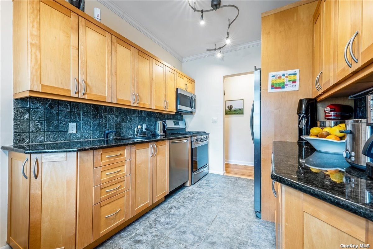 a kitchen with stainless steel appliances granite countertop a refrigerator a stove and a sink