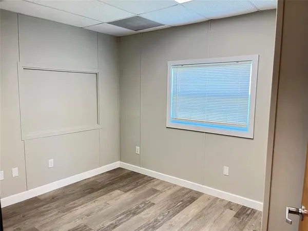 a view of a small space with wooden floor and a window