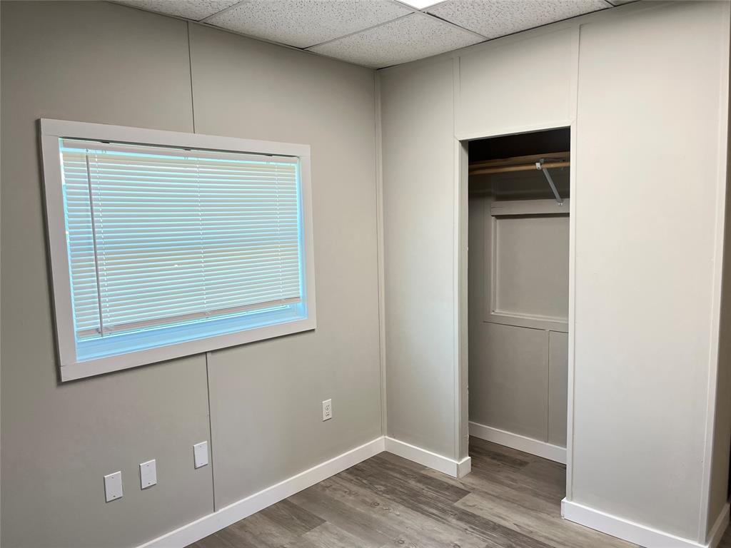 5259 Fm 156 Street North, Unit 6 Krum, TX 76249 - Photo 8 of 16 a view of an empty room with wooden floor and a window