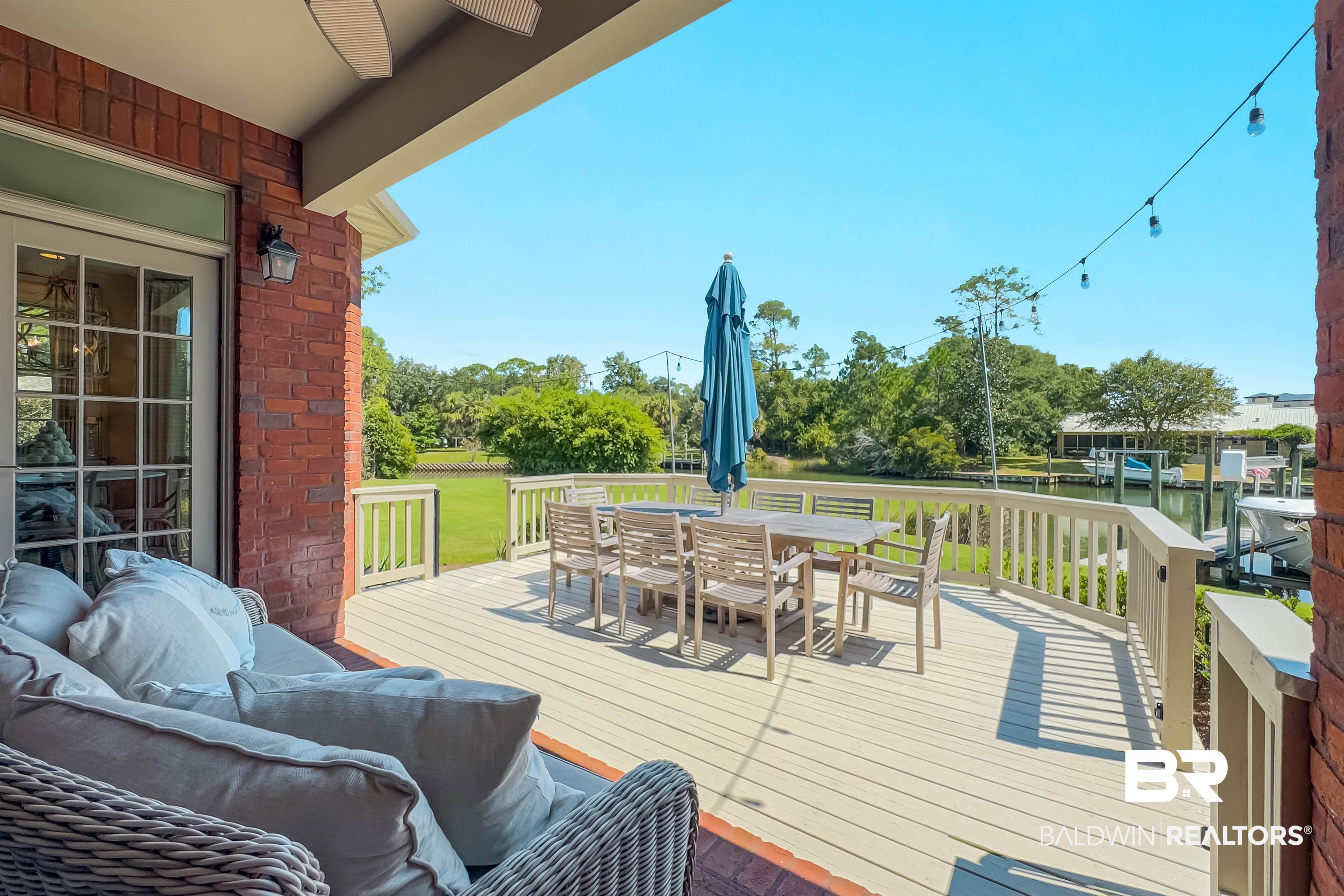 6630 East Quarry Drive Elberta, AL 36530 - Photo 52 of 63 Wooden deck with outdoor dining space, a water view, and a yard