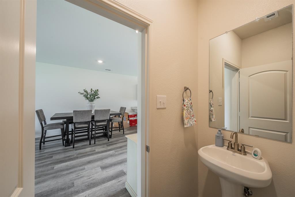 8125 White Sulphur Road Ponder, TX 76259 - Photo 17 of 38 Pedestal sink with brushed nickel faucet, large wall mirror, and neutral wall tones