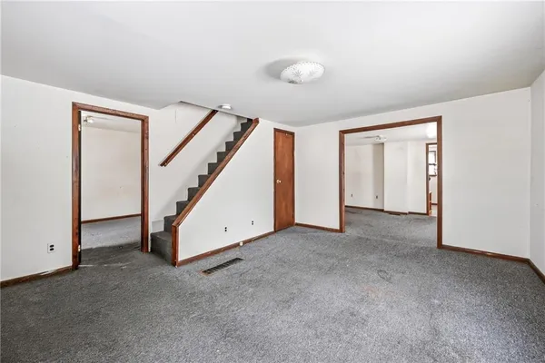 an empty room with closet and windows