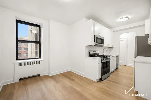 a kitchen with sink a stove and cabinets