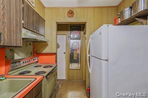 22 Middleville Road Northport, NY 11768 - Photo 9 of 20 Kitchen featuring freestanding refrigerator, electric range oven, under cabinet range hood, and light countertops