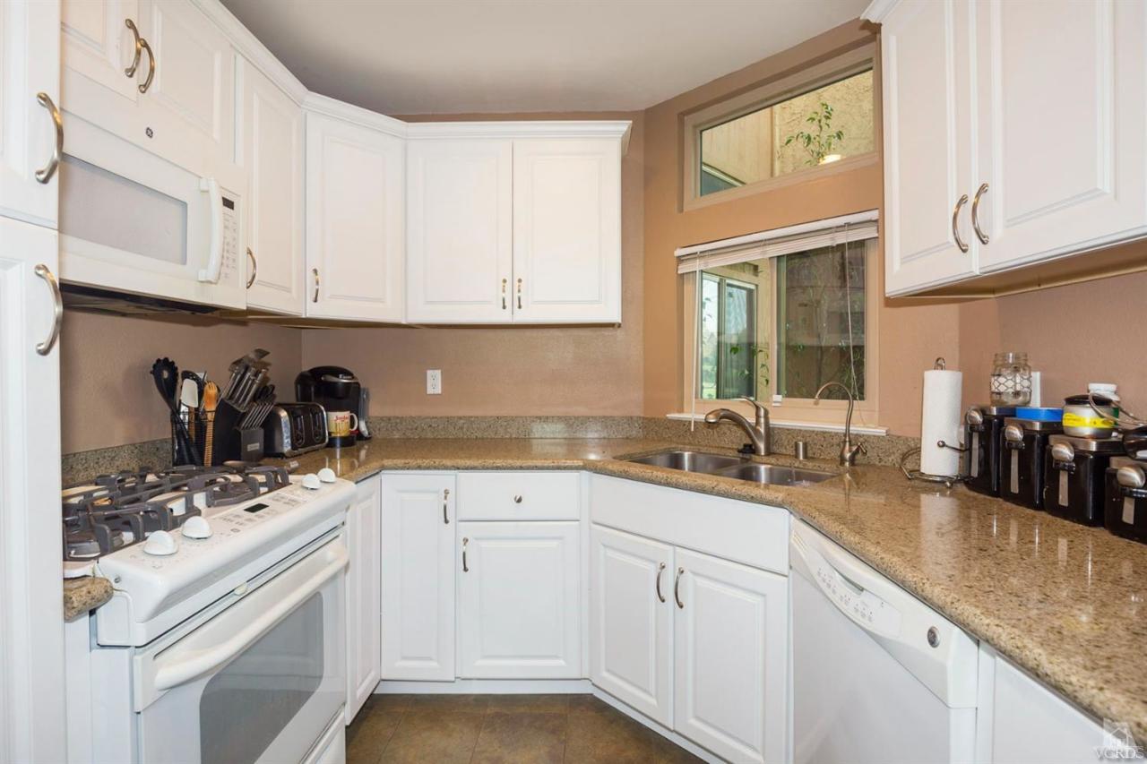 1706 Sinaloa Road, Unit 107 Simi Valley, CA 93065 - Photo 1 of 27 a kitchen with kitchen island granite countertop white cabinets and white appliances