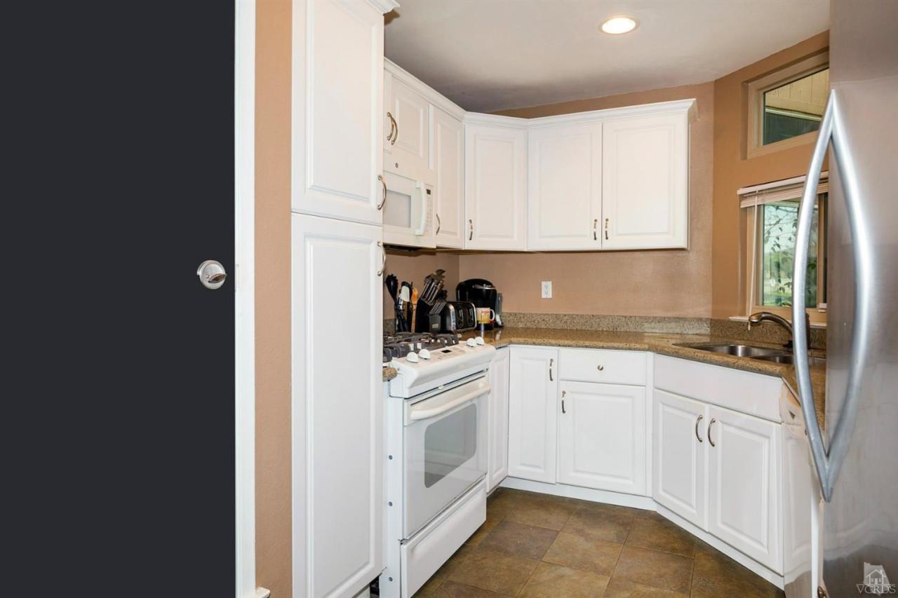 1706 Sinaloa Road, Unit 107 Simi Valley, CA 93065 - Photo 11 of 27 a kitchen with white cabinets and white appliances