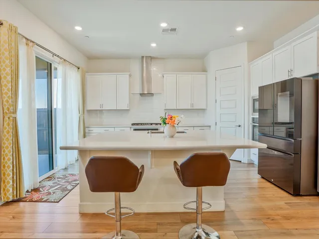 a kitchen with stainless steel appliances granite countertop a refrigerator and a stove top oven