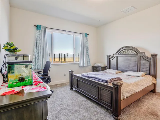 a bedroom with a bed window and dresser