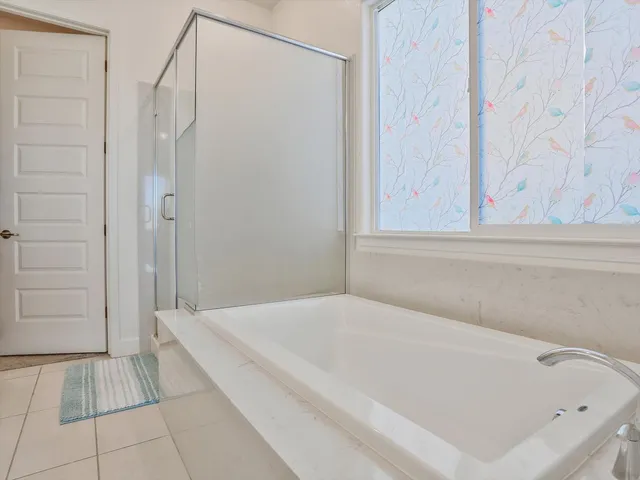 a spacious bathroom with a bathtub and shower