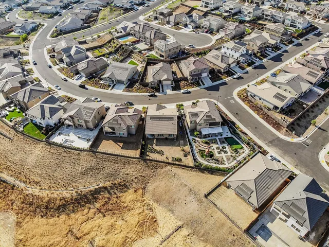 an aerial view of a swimming pool with lawn chairs and plants
