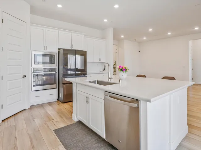 a kitchen with stainless steel appliances a refrigerator sink and microwave