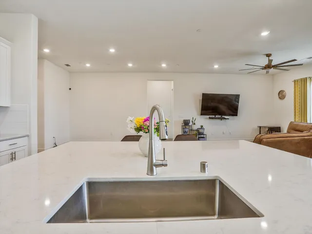 a kitchen with stainless steel appliances a sink a microwave a refrigerator and a sink