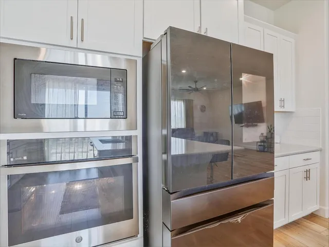 a view of a kitchen with granite countertop a refrigerator and a stove