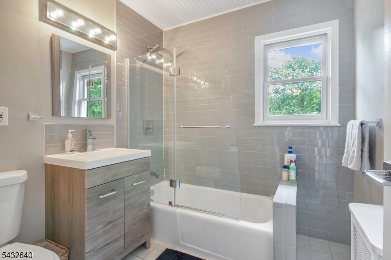 46 Hazelwood Road Bloomfield, NJ 07003 - Photo 6 of 14 a bathroom with a sink a toilet a mirror a bathtub and shower