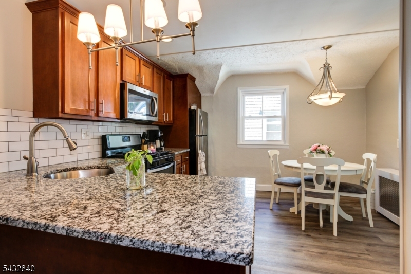 46 Hazelwood Road Bloomfield, NJ 07003 - Photo 8 of 14 a kitchen with a dining table chairs and chandelier