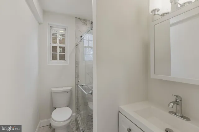 a white toilet sitting next to a bathroom sink